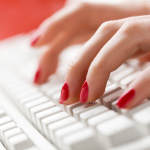 Get Well Guru Woman's fingers typing on keyboard