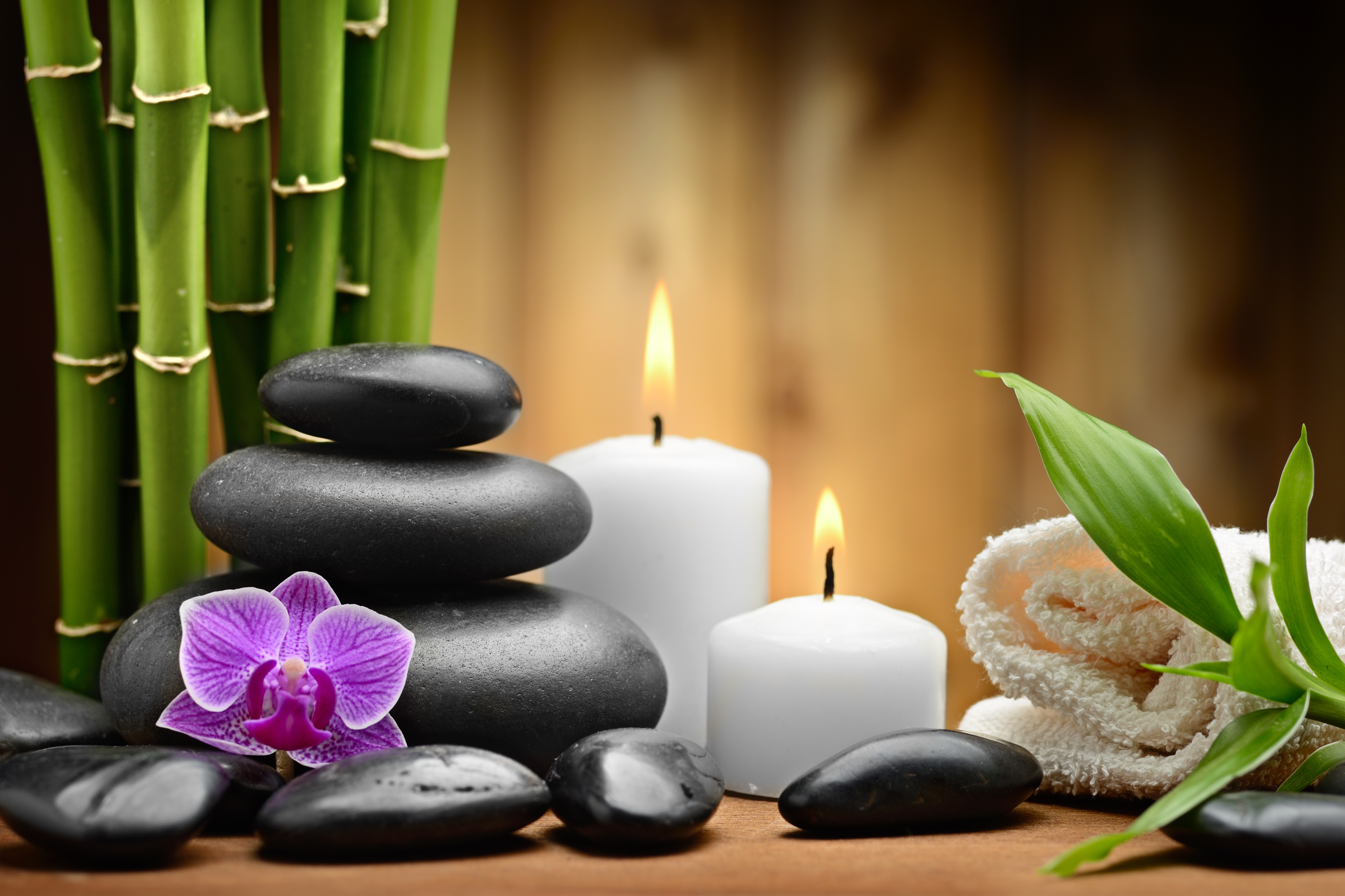 lit candles, black stones, and orchid