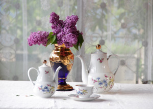 Tea in a cup, a bouquet of a lilac and beautiful service for Nancy Knows Us