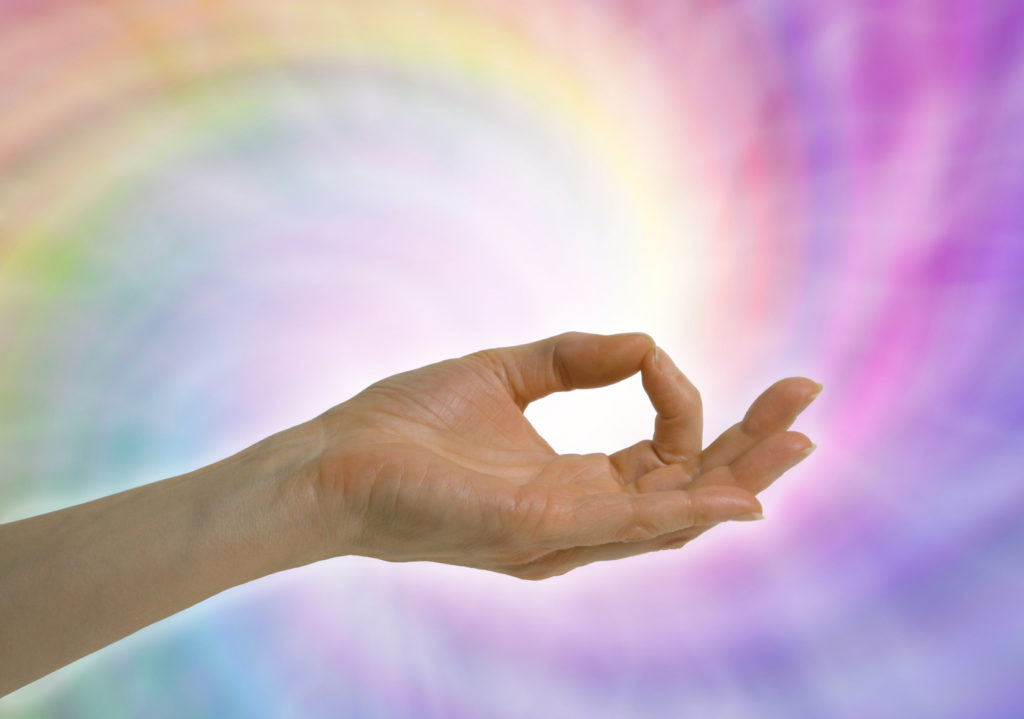 hand in meditation pose with rainbow colored background against rainbow colors as she offers blessing to those with MS