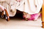 The child hides under a bed. Violence in a family.