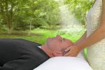 Man receiving Reiki treatment which may help alleviate pain