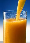 orange juice being poured into a glass