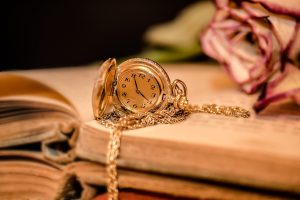 soft toned image of a book, a watch, and a rose