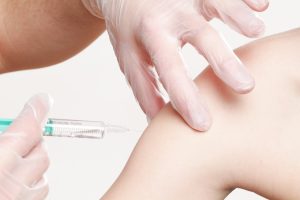 photo of hands giving flu injection into patient's arm by whitesession